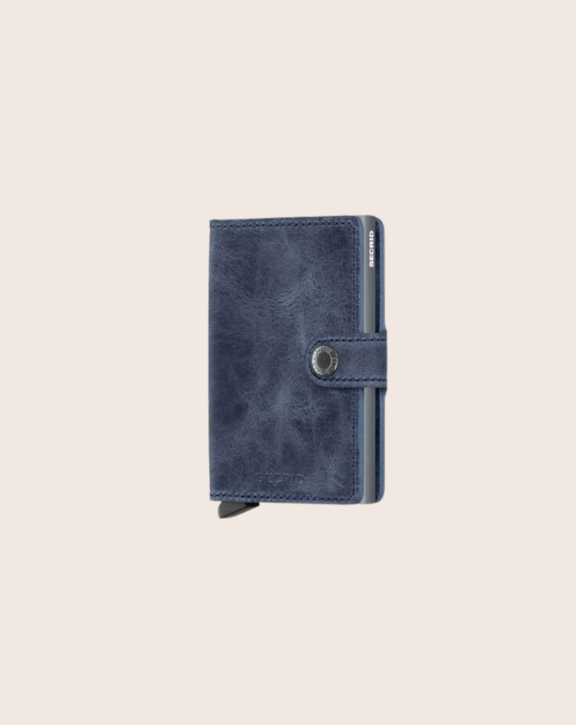 Blaues Lederportemonnaie mit Druckknopf und sichtbaren Kartenfächern, stilvolles Design für Schreibwarenliebhaber.